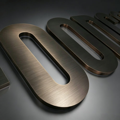 Antique brass channel letters unlit, showing brushed bronze finish and depth